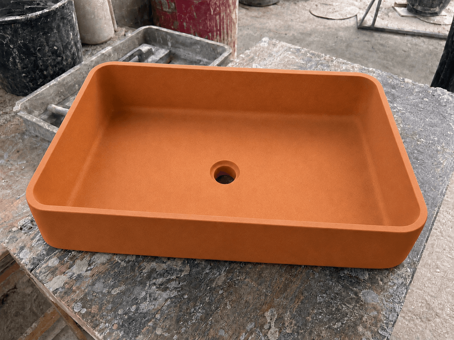 Cuba de concreto naranja con acabado liso y profesional